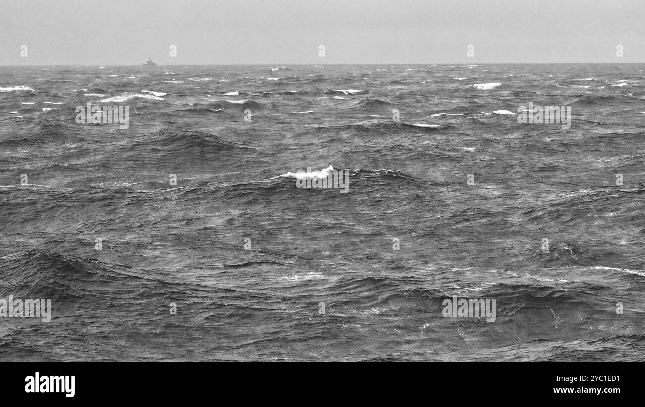 Una giornata cupa e un'ondata instabile nello stretto di Cook tra le isole Nord e Sud della nuova Zelanda, con una nave debole all'orizzonte Foto Stock