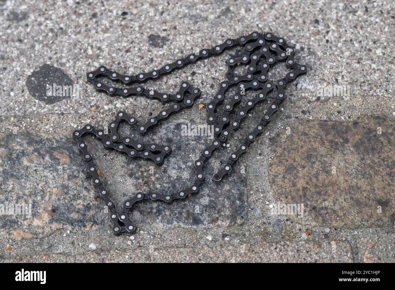 Una catena di biciclette adagiata su una strada acciottolata, Copenaghen, Danimarca, Europa Foto Stock