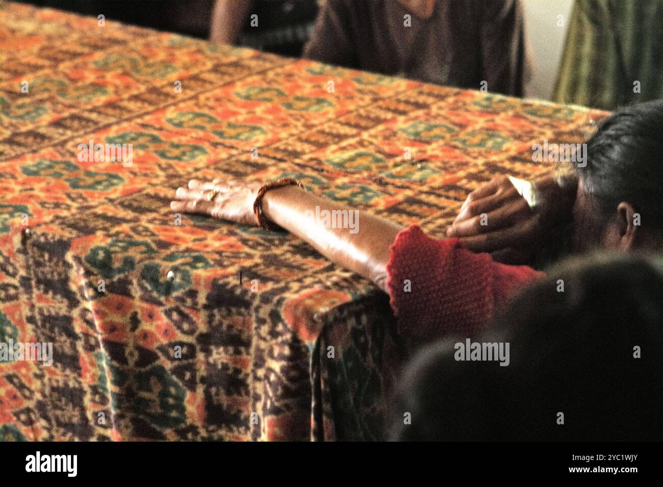 Una donna piange durante una sessione di lutto mentre uno dei suoi familiari è morto a Kilimbatu, Kawangu, Pandawai, Sumba orientale, Nusa Tenggara orientale, Indonesia. La tradizione legata alla morte nelle comunità subanesi richiede un invito da parte della famiglia in lutto su chi dovrebbe venire all'evento. Foto Stock