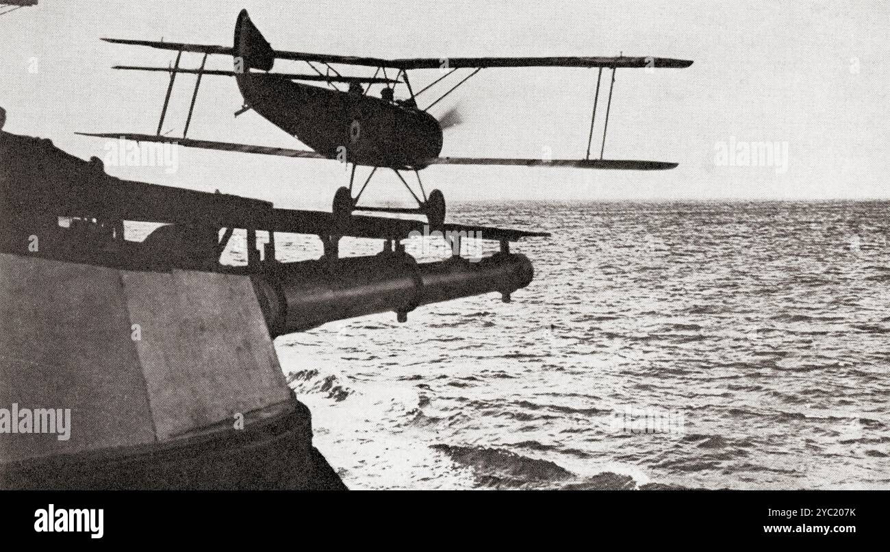 Un Sopwith 1½ Strutter che decollava da una piattaforma equipaggiata con i cannoni di una nave da guerra britannica durante la prima guerra mondiale. Da Wings of War, pubblicato nel 1942. Foto Stock