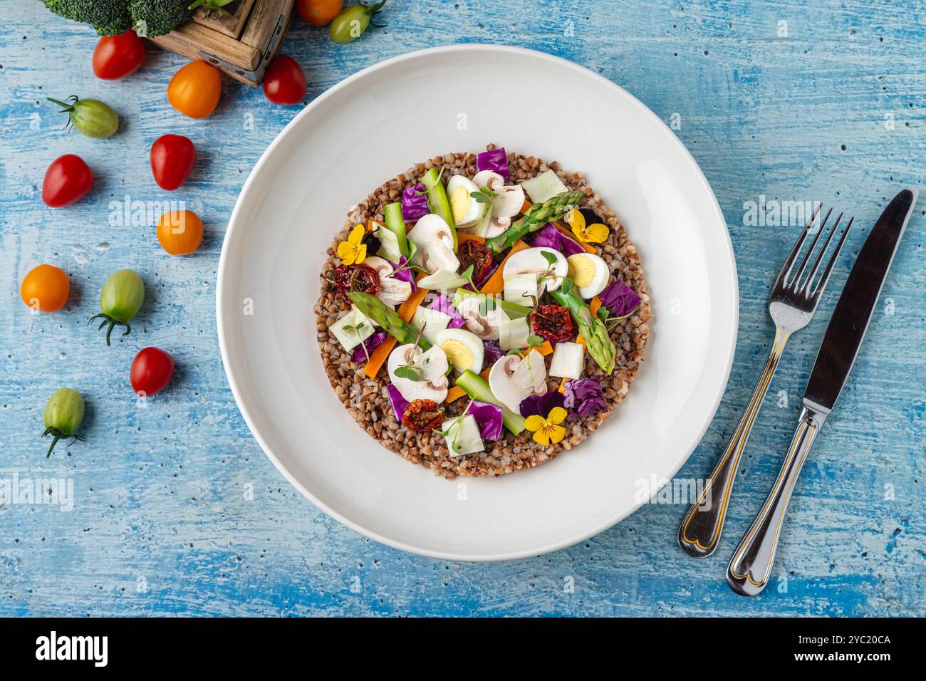 Insalata di quinoa con funghi, uova e pomodori secchi serviti su un piatto di porcellana bianca Foto Stock