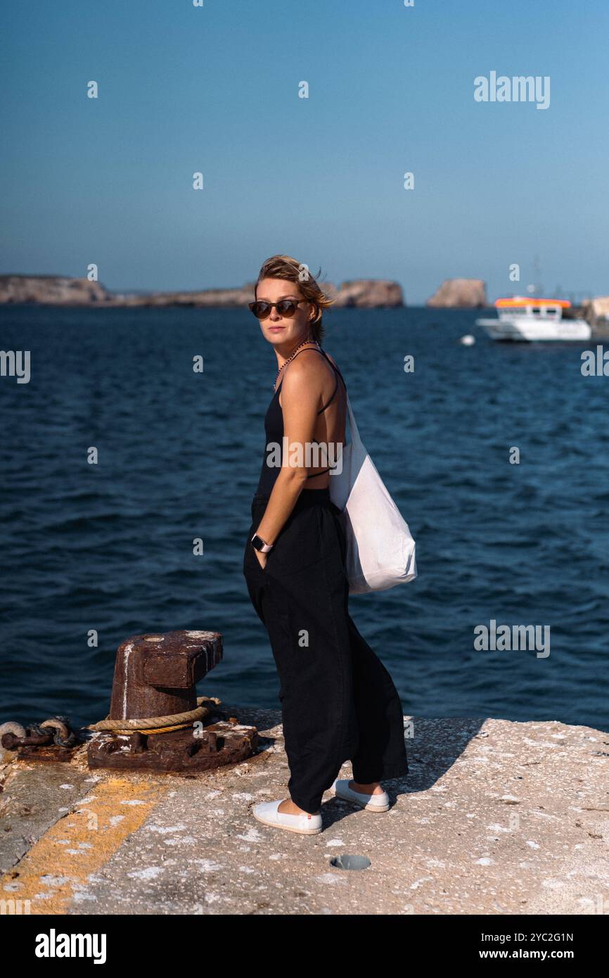 Una donna sta sul molo del porto, Sagres, Portogallo. Foto Stock