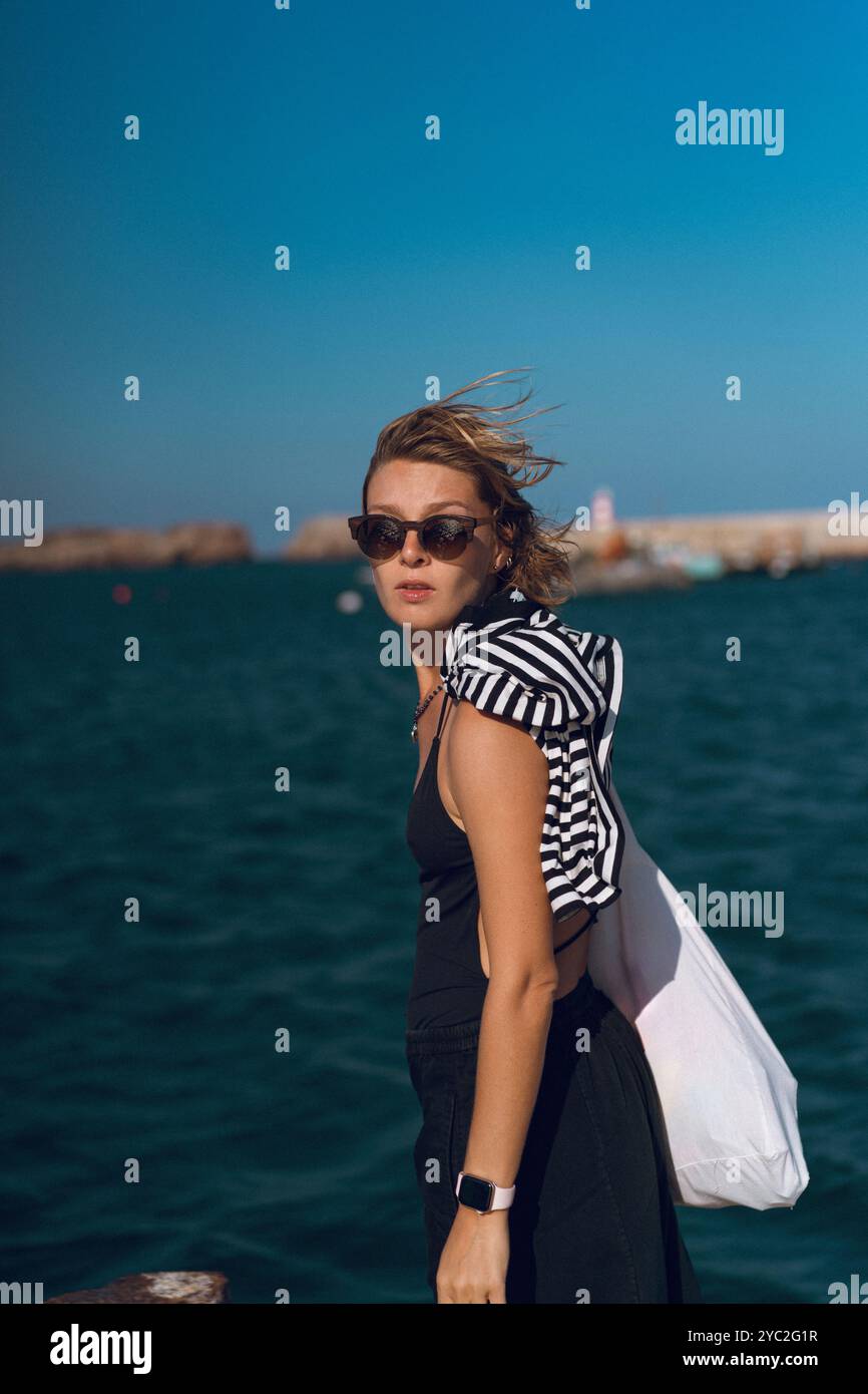 Una donna sta sul molo del porto, Sagres, Portogallo. Foto Stock