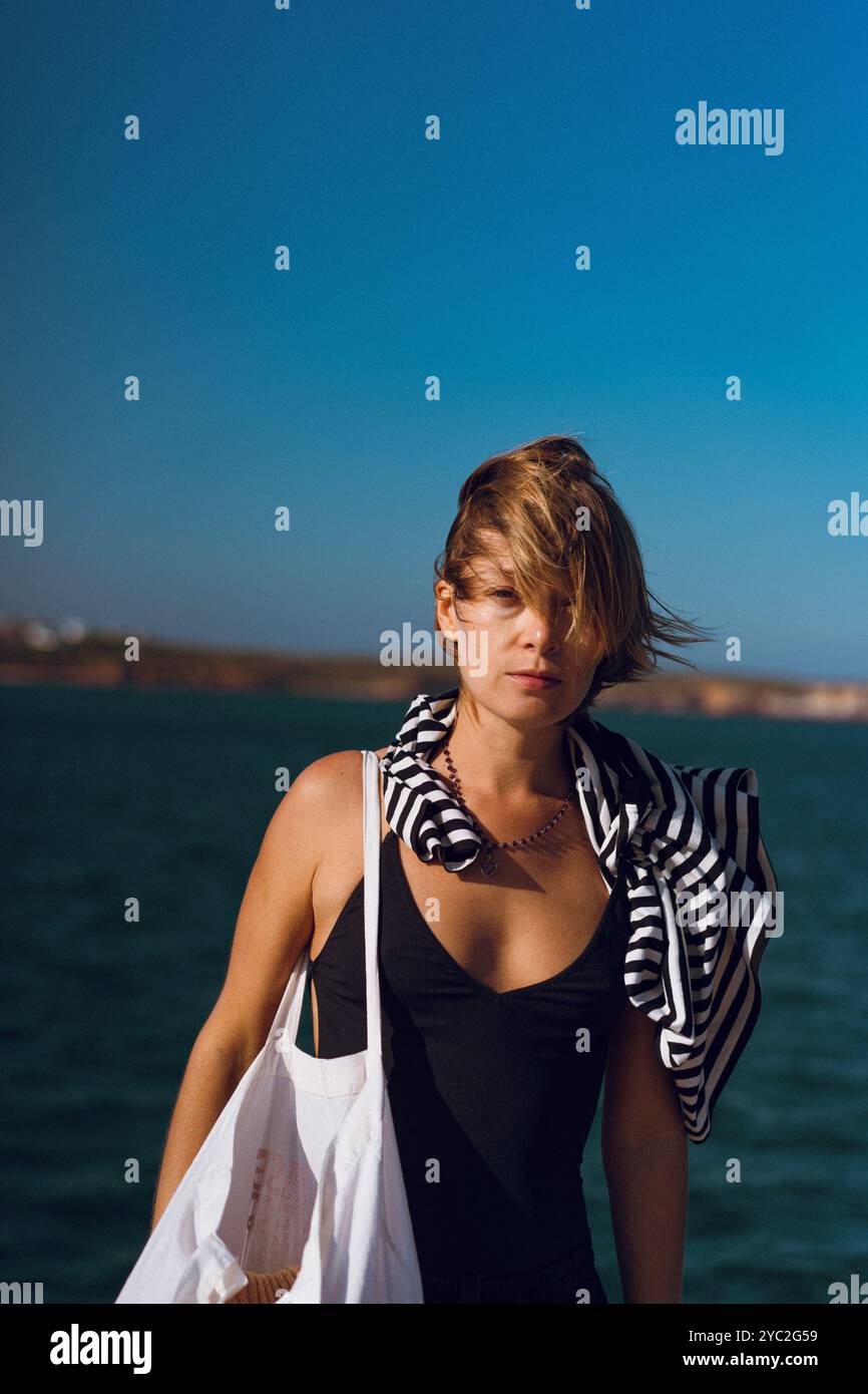 Una donna sta sul molo del porto, Sagres, Portogallo. Foto Stock