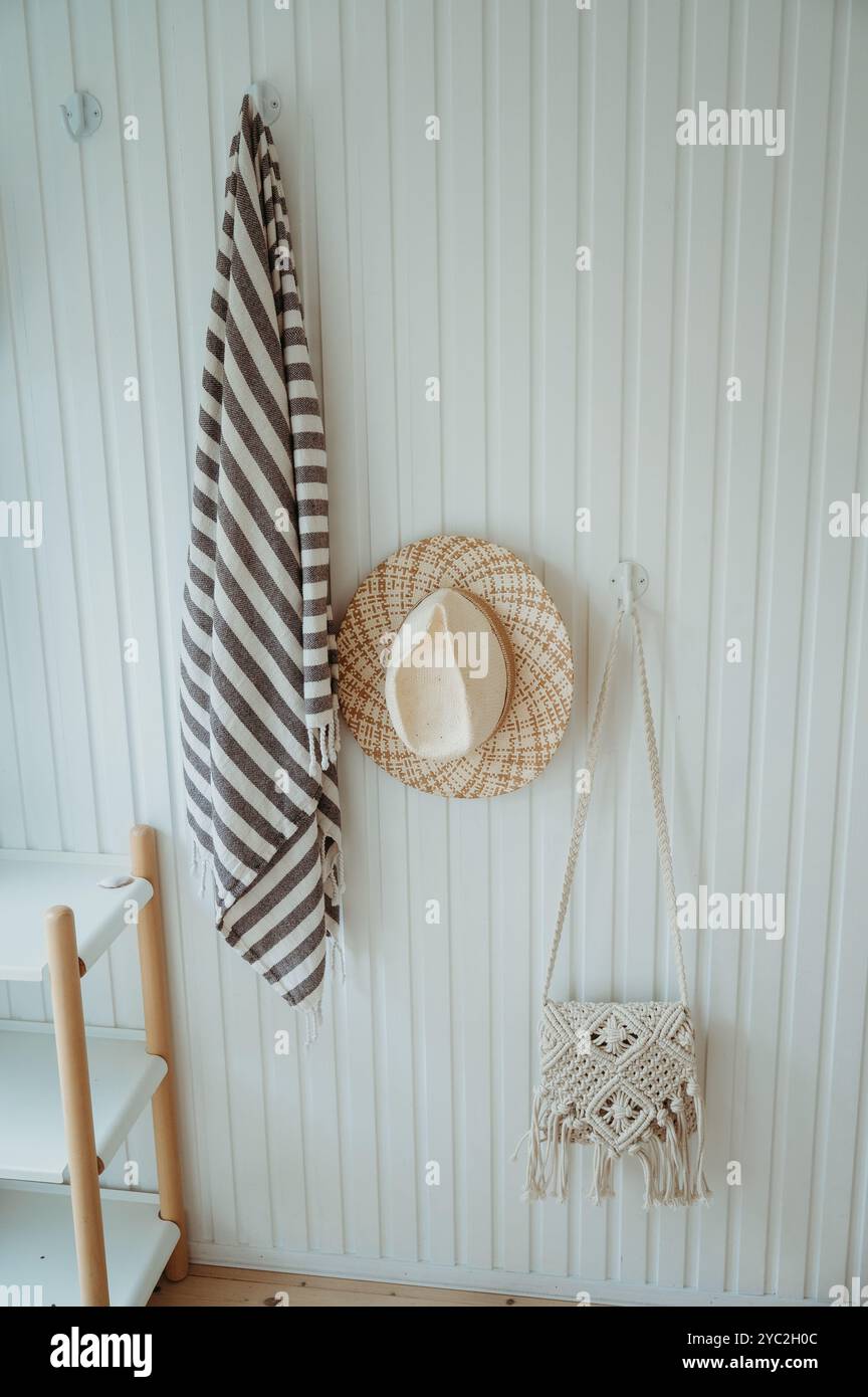 Telo da mare, cappello di paglia e borsa in macramé in una casa sulla spiaggia danese Foto Stock