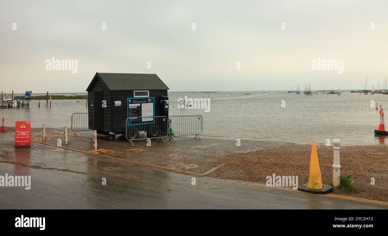 Un parcheggio inondato da una marea primaverile che sovrasta il canale del porto sulla costa nord del Norfolk a Blakeney, Norfolk, Inghilterra, Regno Unito. Foto Stock