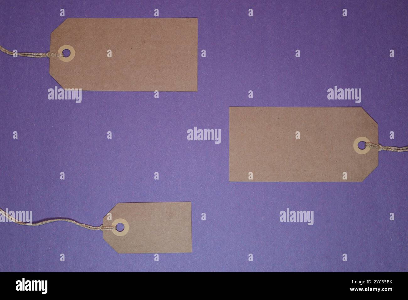 Etichette di carta marrone vuote su sfondo viola Foto Stock