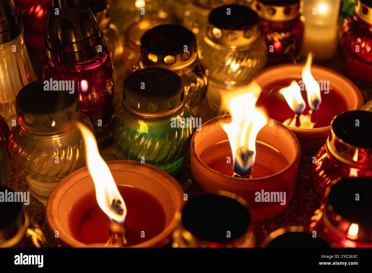 sereno lume di candela in vasi colorati durante il memoriale notturno Foto Stock