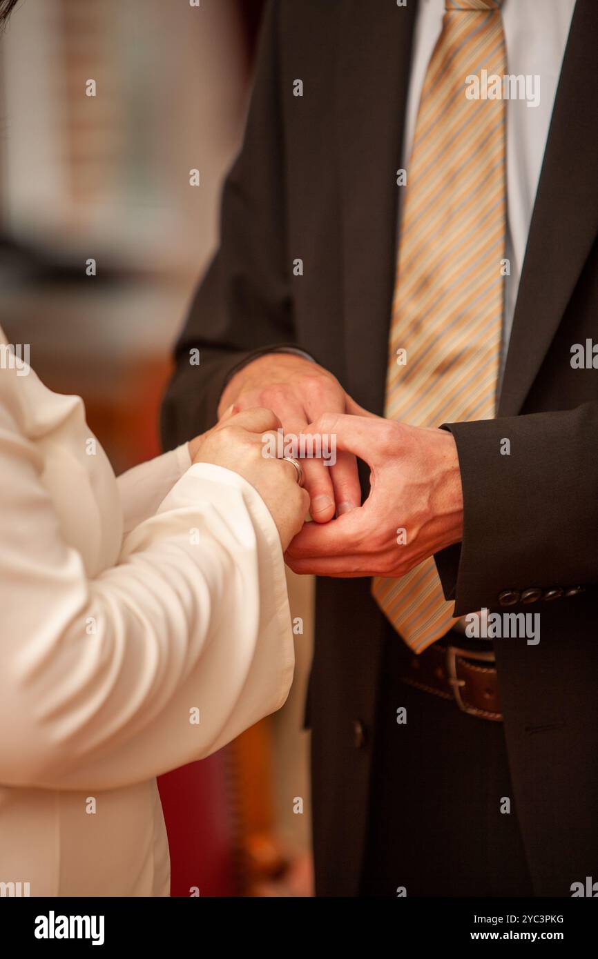 Una coppia amorevole che si scambiava i propri voti con le mani amorevolmente intrecciata in un bellissimo momento di nozze Foto Stock