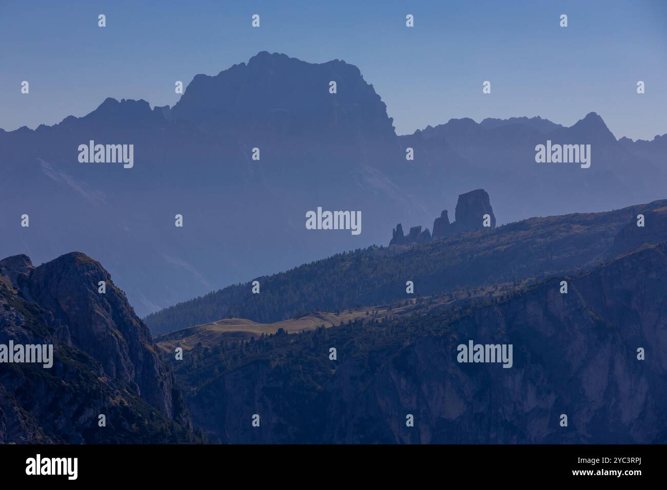 Cielo nebbioso con nuvole e profili montani nella nebbia in autunno. Orizzonte cielo con alte cime montuose che si stagliano nelle Alpi dolomitiche nel blu Foto Stock