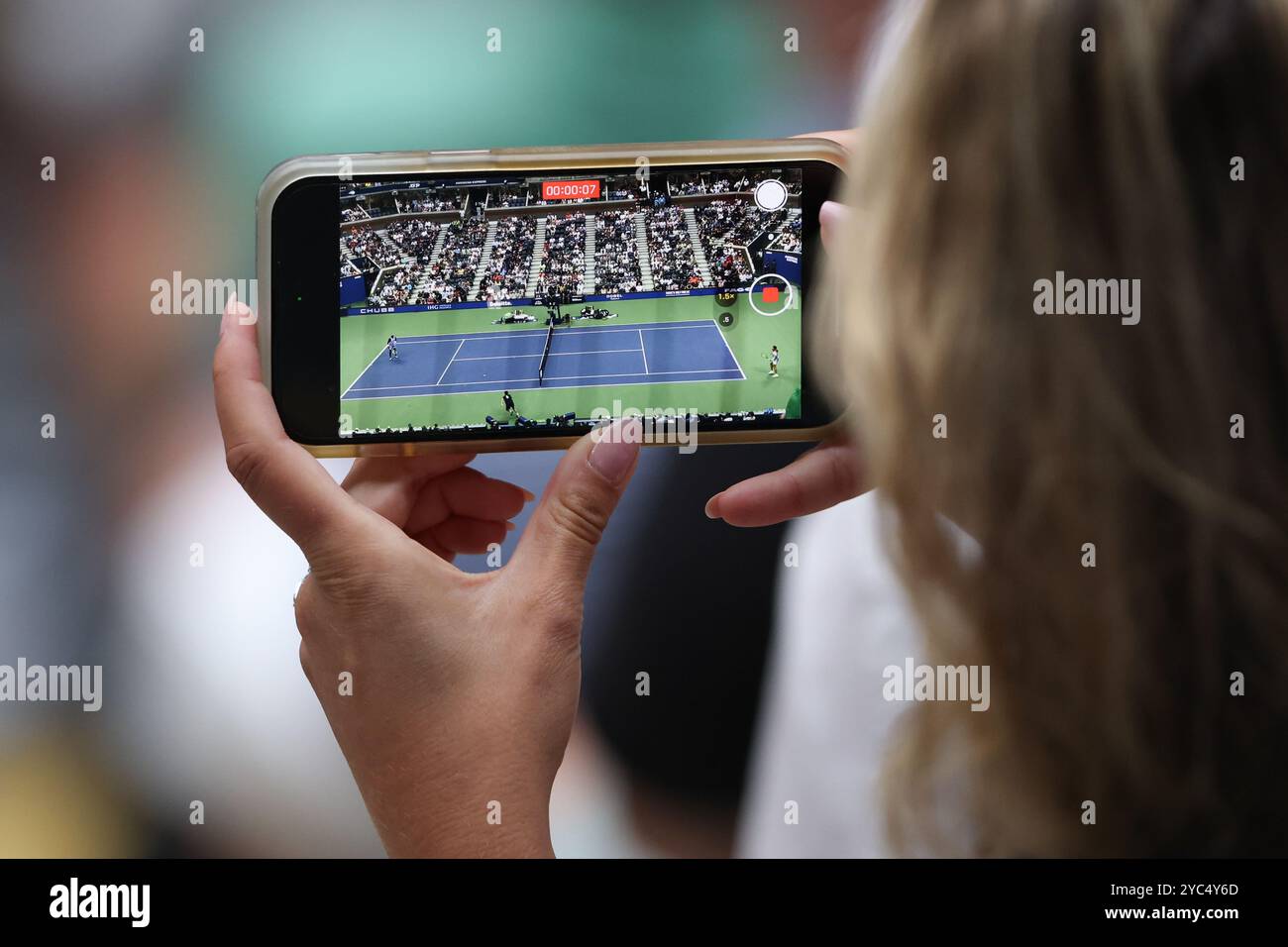 Lo spettatore registra una partita di tennis con il cellulare all'Arthur Ashe Stadium durante una partita agli US Open 2024 Championships, Billie Jean King Tennis Foto Stock