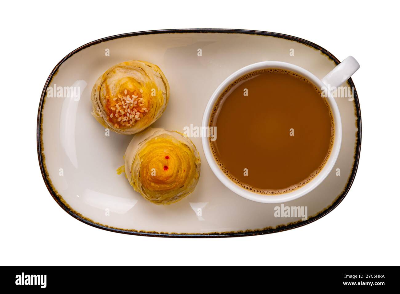 Vista dall'alto del caffè a latte caldo in tazza di ceramica bianca con torta di mooncake cinese in vassoio di ceramica marrone con bordo scuro isolato su sfondo bianco con c Foto Stock