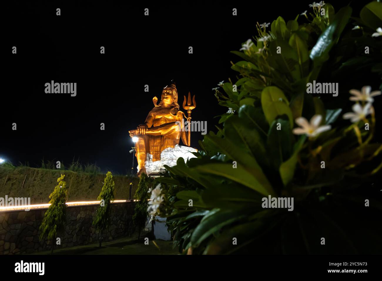 Statua isolata del santo signore indù Shiva nella postura della meditazione con cielo nero scuro di notte Foto Stock