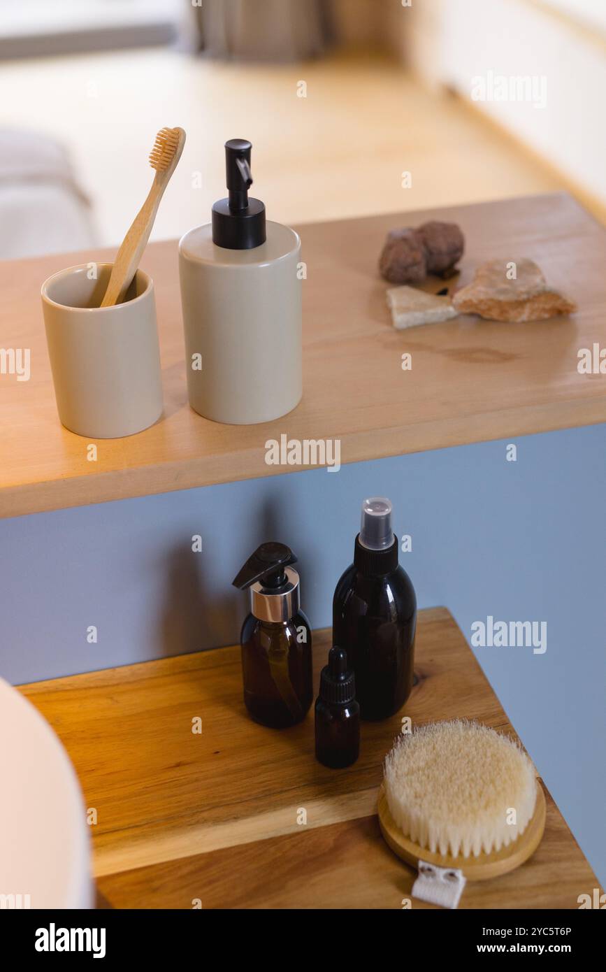 Gli accessori naturali per il bagno sono disposti in modo ordinato su un ripiano in legno in una casa accogliente Foto Stock