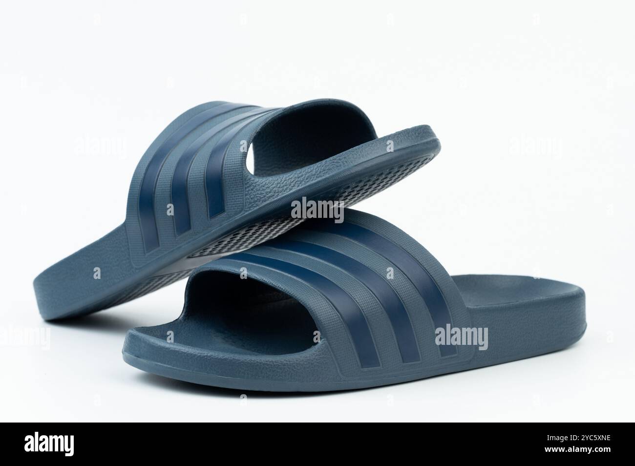 I sandali slide blu navy offrono comfort e praticità, ideali per il relax della casa o per le uscite informali nelle giornate più calde. Foto Stock