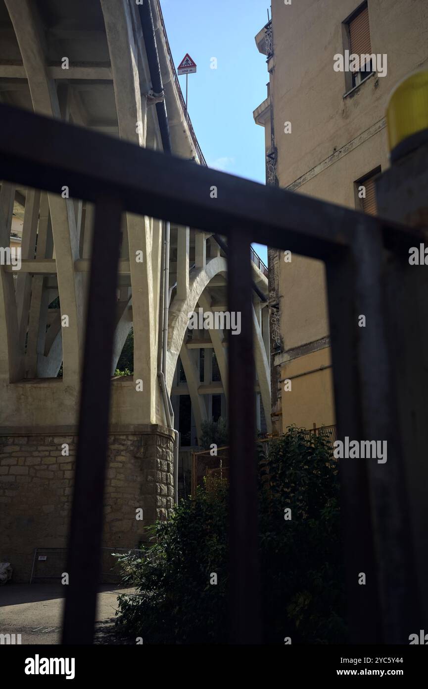 Viadotto che passa sopra una città accanto a un edificio in una giornata di sole Foto Stock