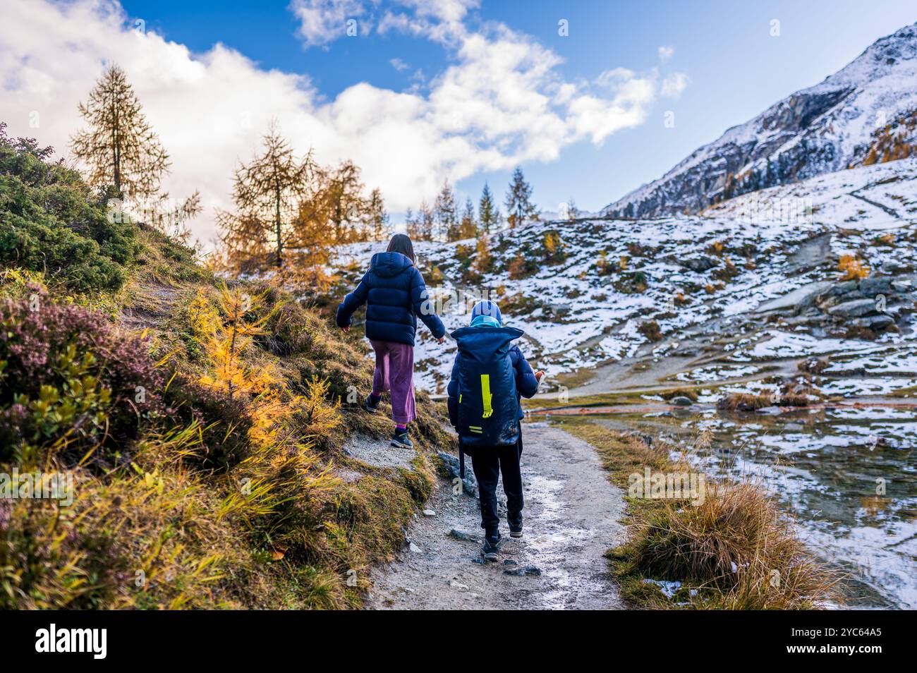 Gente che fa escursioni in autunno. Paesaggio delle montagne, del cielo e della foresta. Montagna innevata. La Gouille, Evolene, Svizzera. Foto Stock