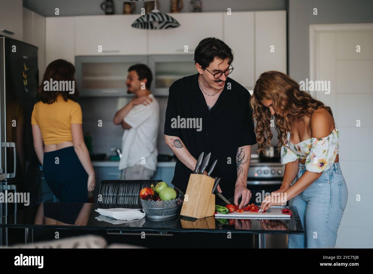 Amici che si godono una sessione di cucina informale in cucina Foto Stock
