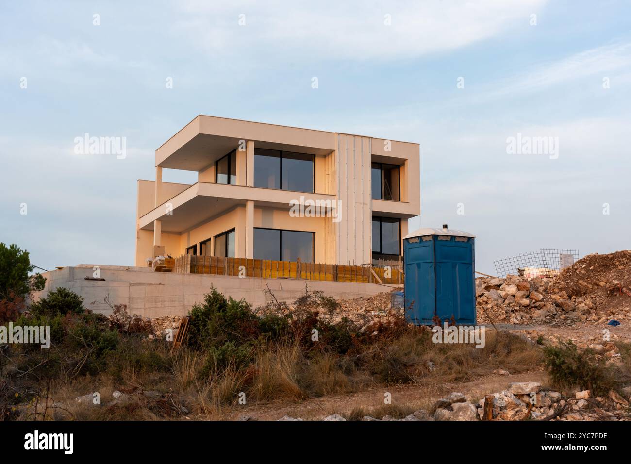 Moderna casa a due piani in costruzione in un'area rurale durante il tramonto. Foto Stock