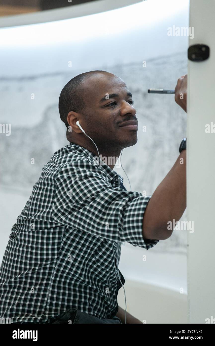 Il famoso artista Stephen Wiltshire sorride mentre disegna il paesaggio urbano di Singapore attraverso la sua incredibile memoria fotografica con un unico look, Foto Stock