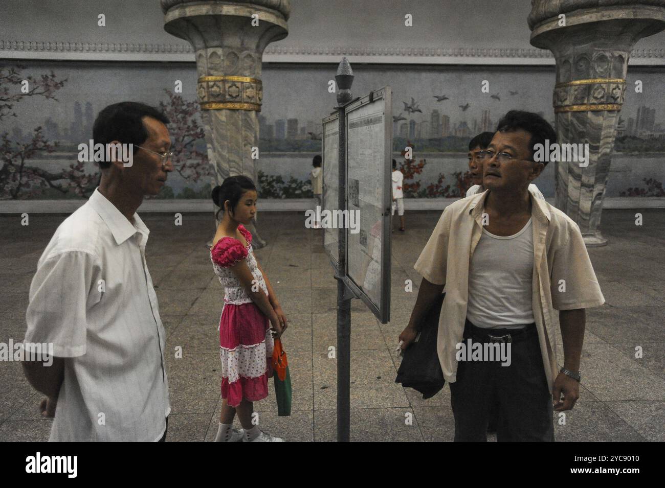 09.08.2012, Pyongyang, Corea del Nord, Asia, passeggeri in attesa di leggere i giornali sulla piattaforma sotterranea, Asia Foto Stock