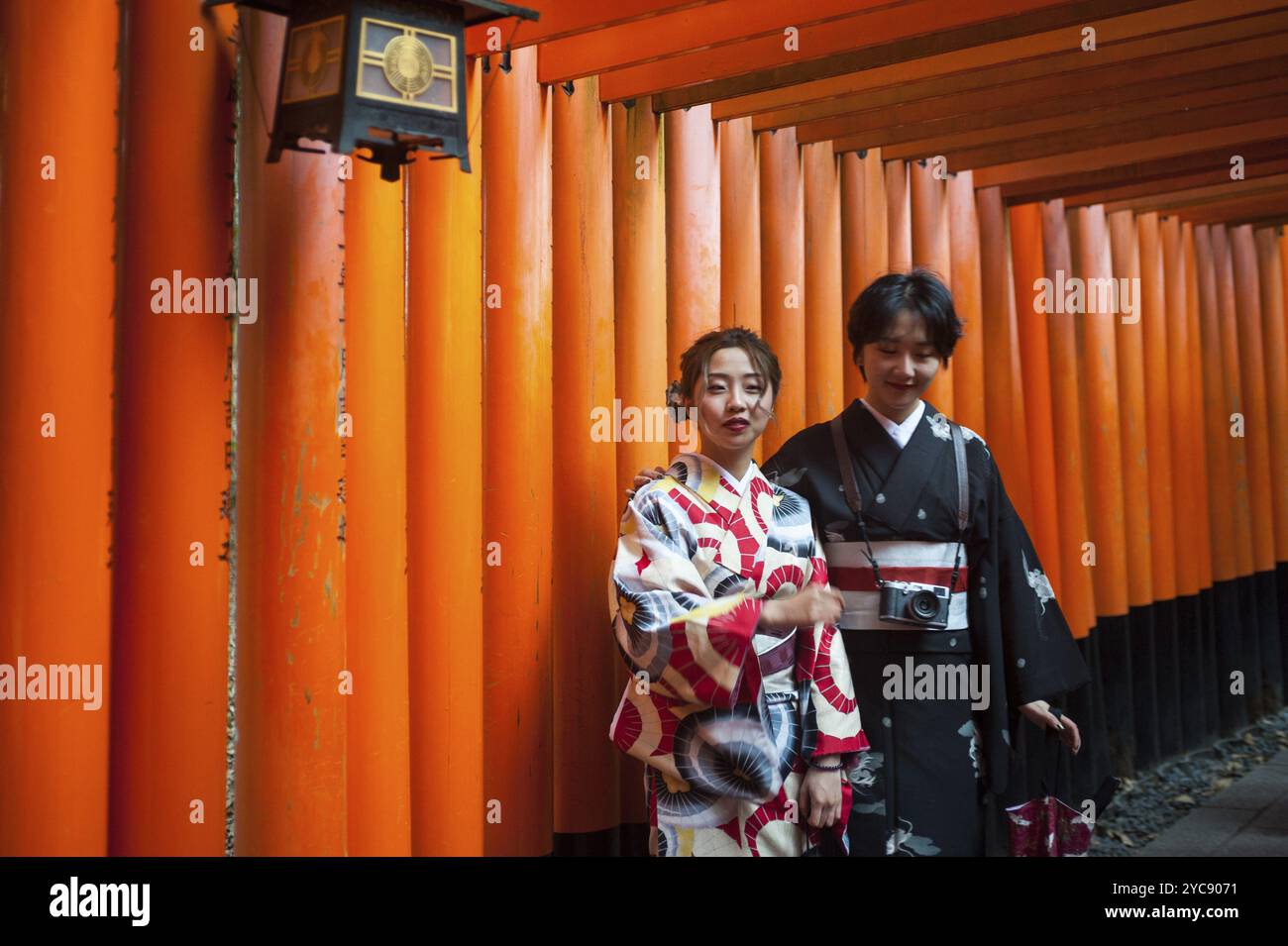 24.12.2017, Kyoto, Giappone, Asia, due giovani donne giapponesi si trovano in uno dei percorsi torii che portano al Fushimi Inari-Taisha, un santuario shintoista nel fu Foto Stock