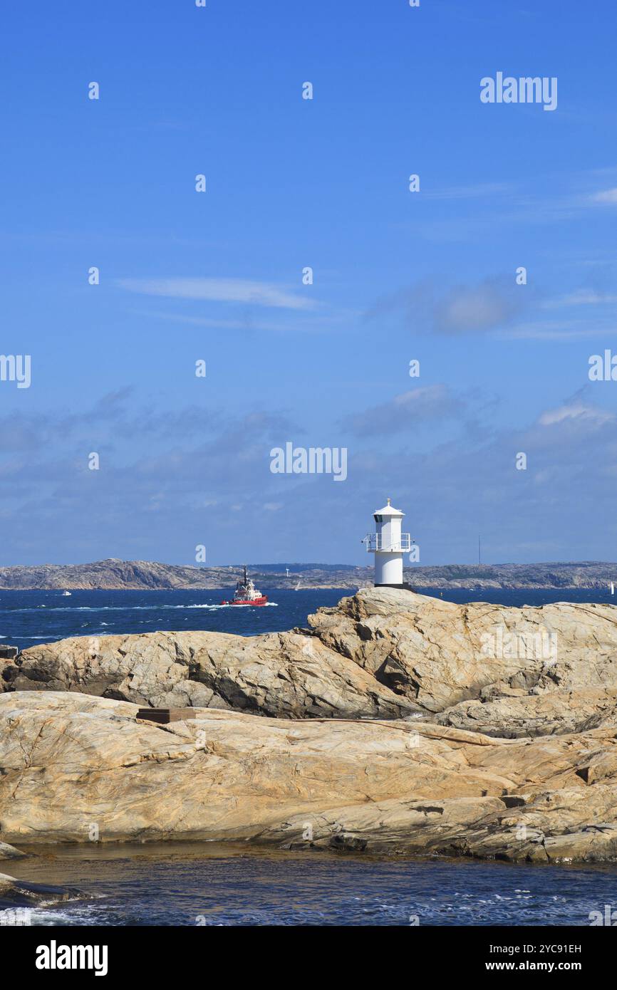 Rimorchiatore a traino e faro di arcipelago del mare Foto Stock