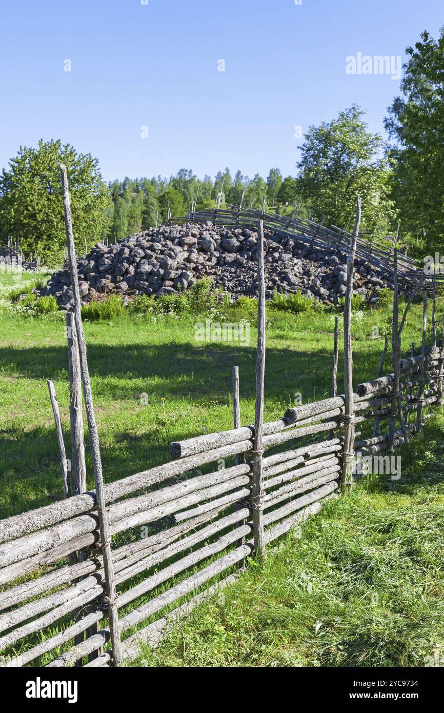 Recinti di legno con una pietra cairn in un prato Foto Stock