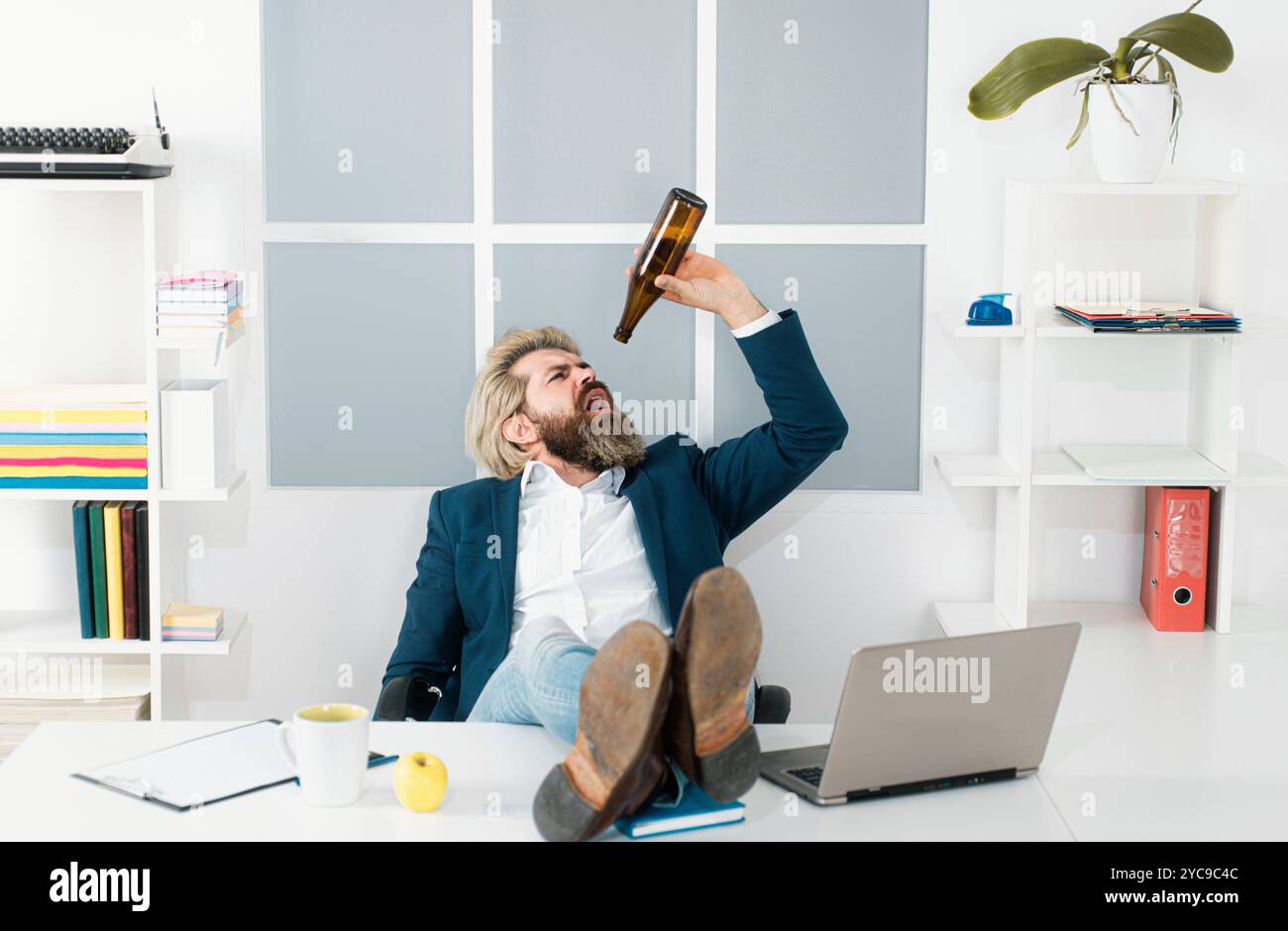 Triste lavoratore d'ufficio disperato sul licenziamento ingiusto perdere lavoro. L'uomo d'affari depresso ha problemi sul lavoro, bevendo alcol in ufficio. Foto Stock