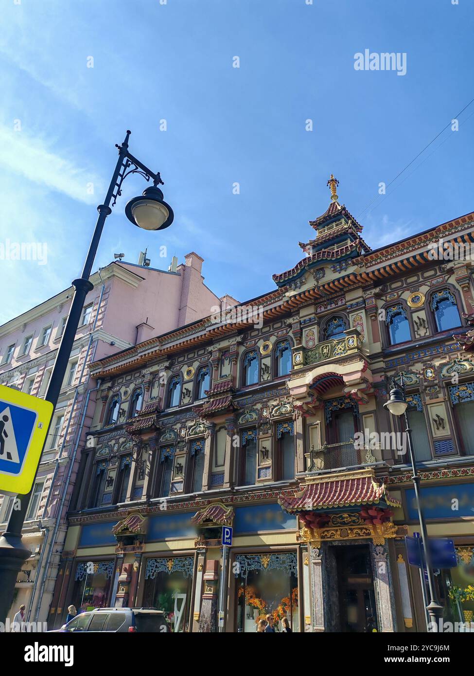 grande edificio giallo con finestre multiple e una porta ad arco, che mostra un design architettonico classico. La struttura riflette la durata Foto Stock