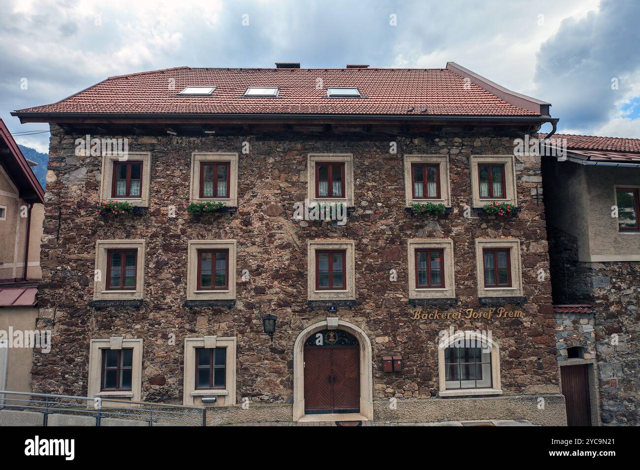 St. Johann im Pongau, stato di Salisburgo, Austria - 21 giugno 2019: Paesaggio estivo con antica casa in pietra sulla strada della città Foto Stock