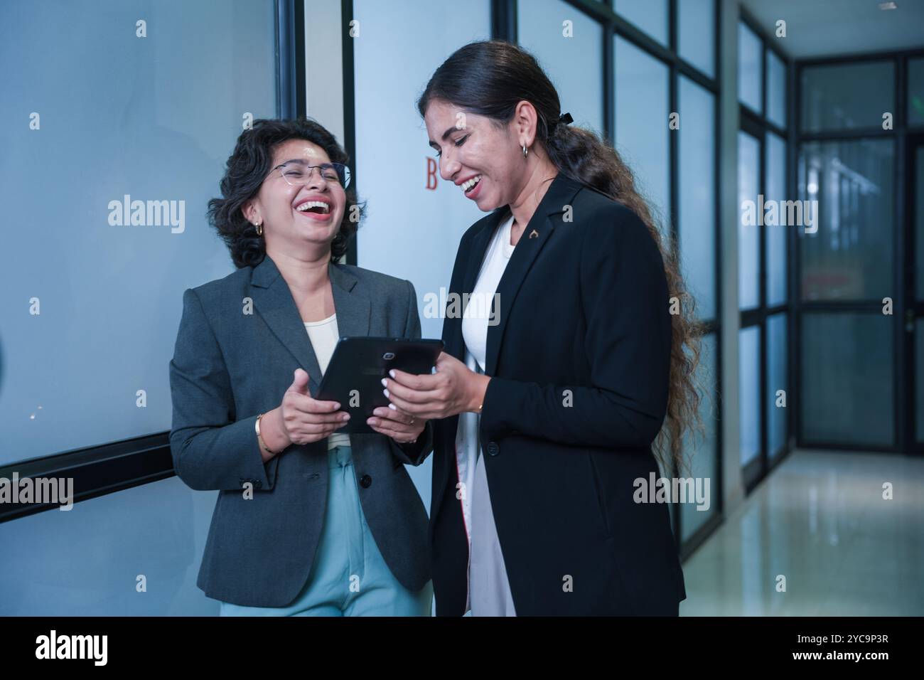 Due donne indiane che si consultano su un nuovo progetto utilizzando un tablet digitale in ufficio. concetto di ambiente di lavoro e tecnologia wireless. Foto Stock