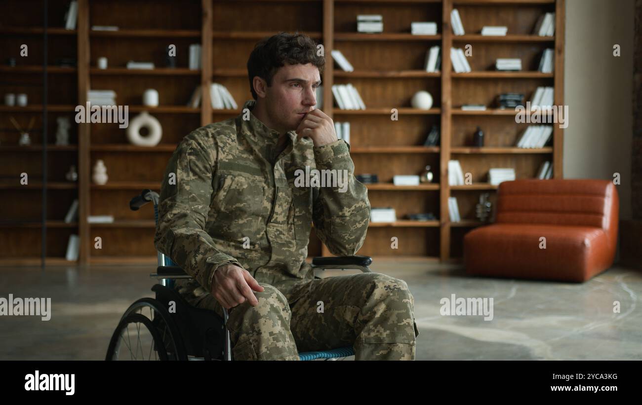 Triste ansioso ufficiale caucasico uomo uniforme da combattimento con disabilità militare militare militare soldato Guy veterano in sedia a rotelle toccando mento viso pensiero Foto Stock