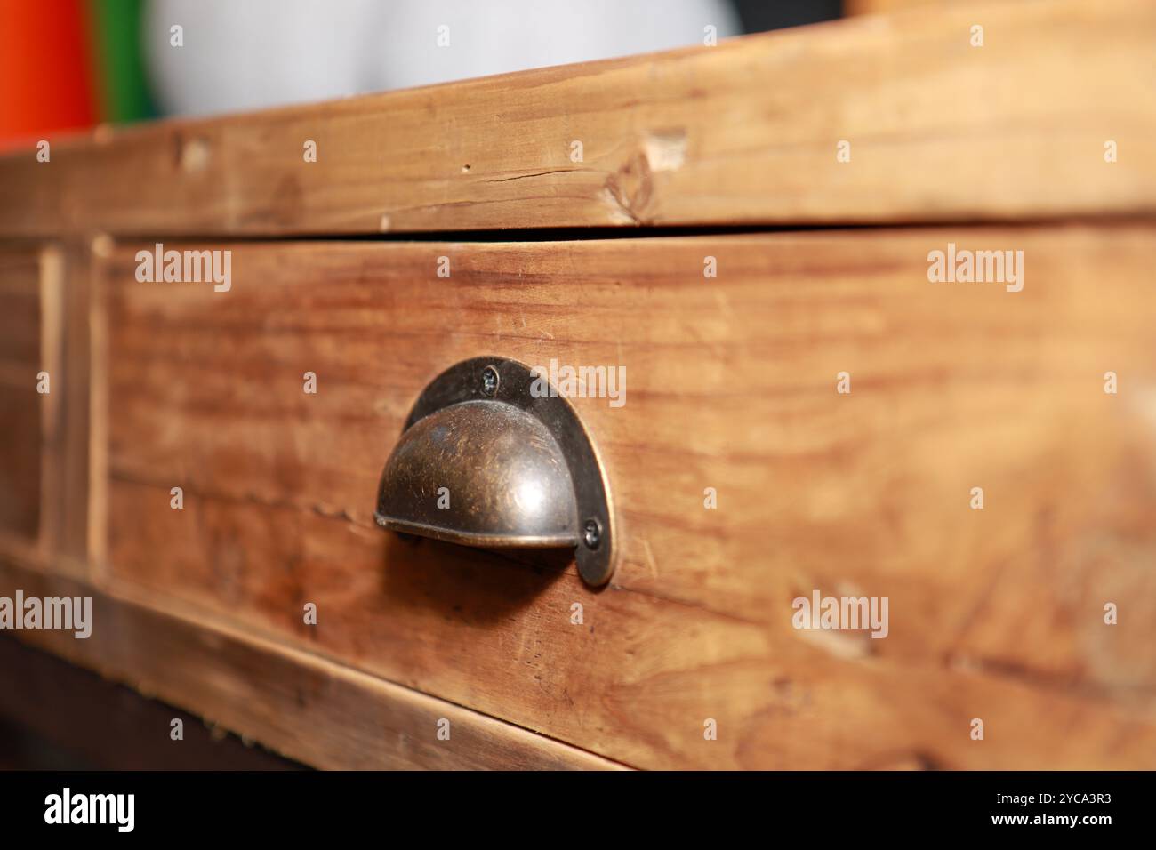Una vecchia tavola laterale rustica fatta a mano che mostra il cassetto in legno e una classica maniglia in ottone Foto Stock