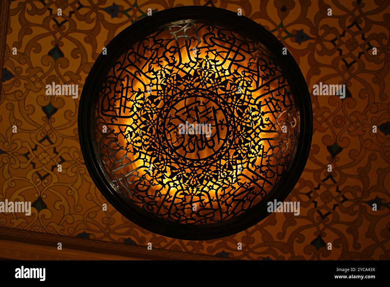 Un lampadario rotondo unico con motivi arabi all'interno della moschea Katara, situato all'interno del Villaggio culturale Katara, un fulcro culturale e commerciale a Doha Foto Stock