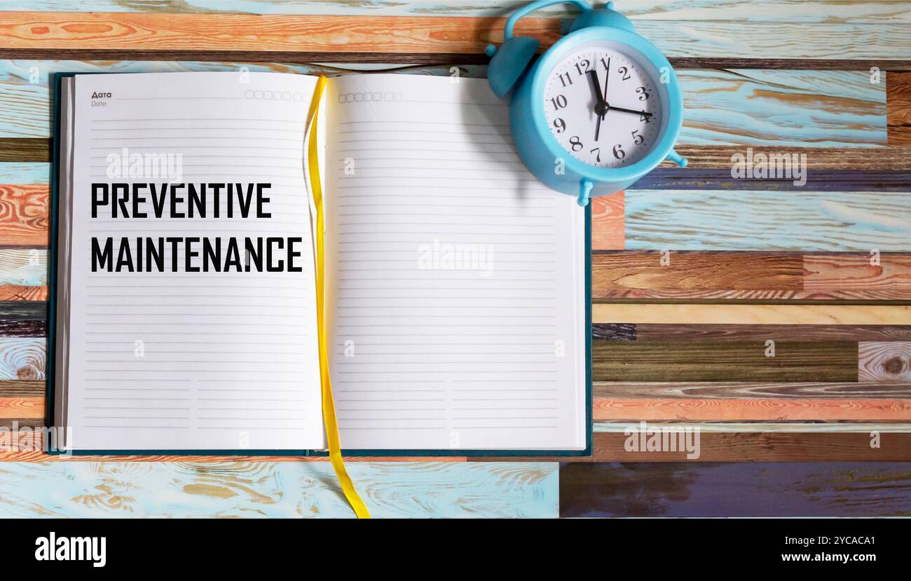 Il concetto del testo sulla manutenzione preventiva, scritto in un notebook, accanto all'orologio Foto Stock
