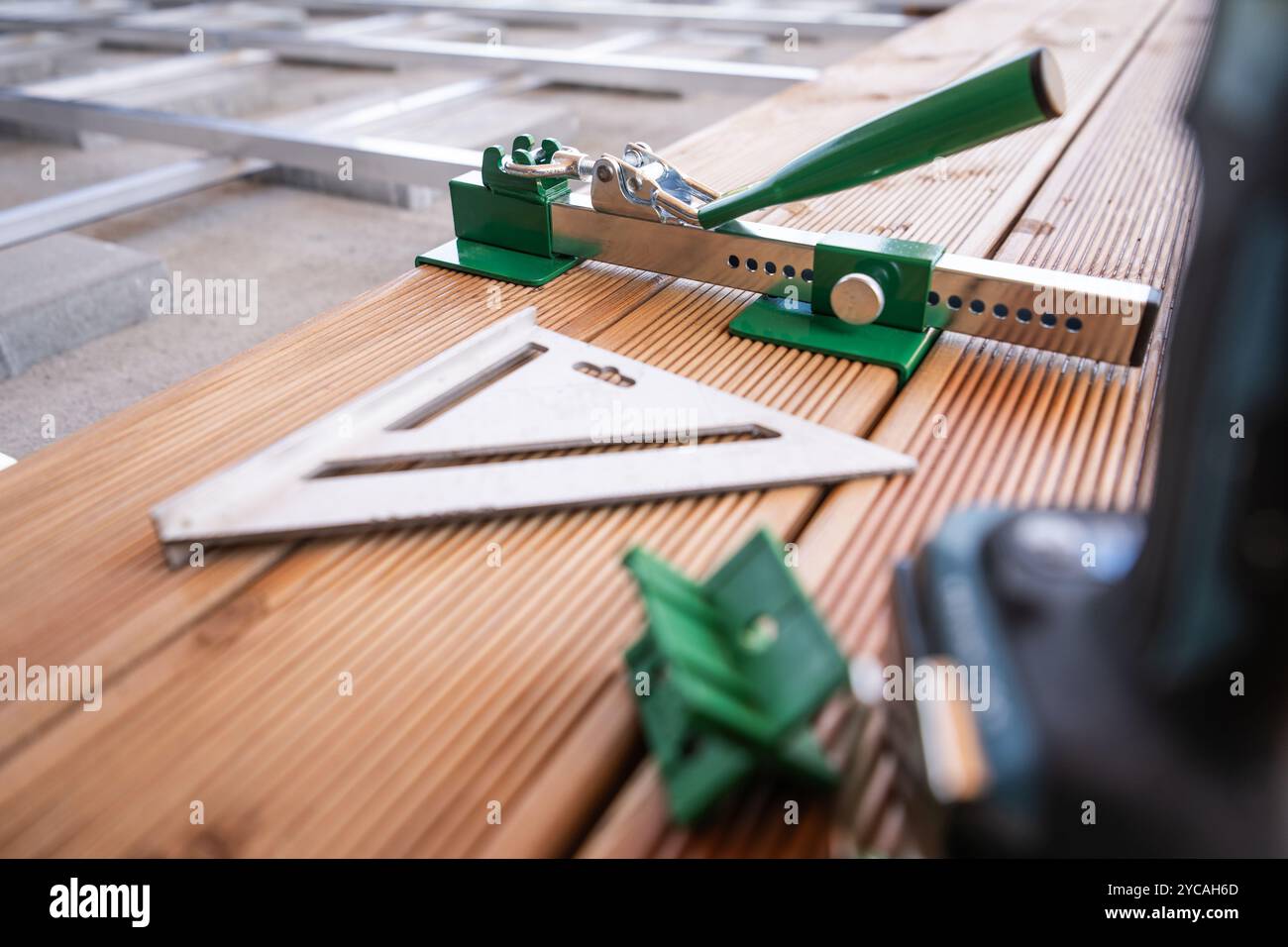 Vari utensili per carpenteria sono montati su tavole di legno, sottolineando la precisione di misurazione e allineamento durante un progetto di lavorazione del legno. Foto Stock