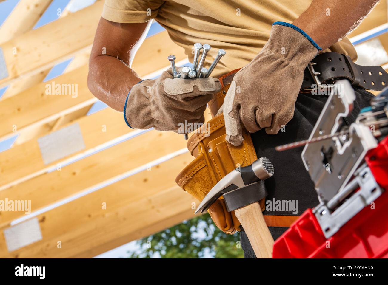 Un falegname prepara gli attrezzi in un'officina, garantendo che tutto sia organizzato per un progetto di lavorazione del legno imminente sotto la luce del sole. Foto Stock