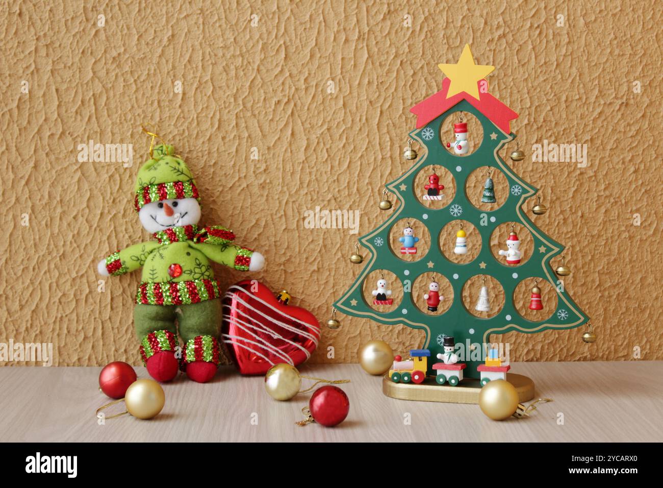 Albero di Natale decorato e pupazzo di neve imbottito indossando abiti rossi e verdi per la stagione invernale. Festeggiamenti natalizi a dicembre. Foto Stock