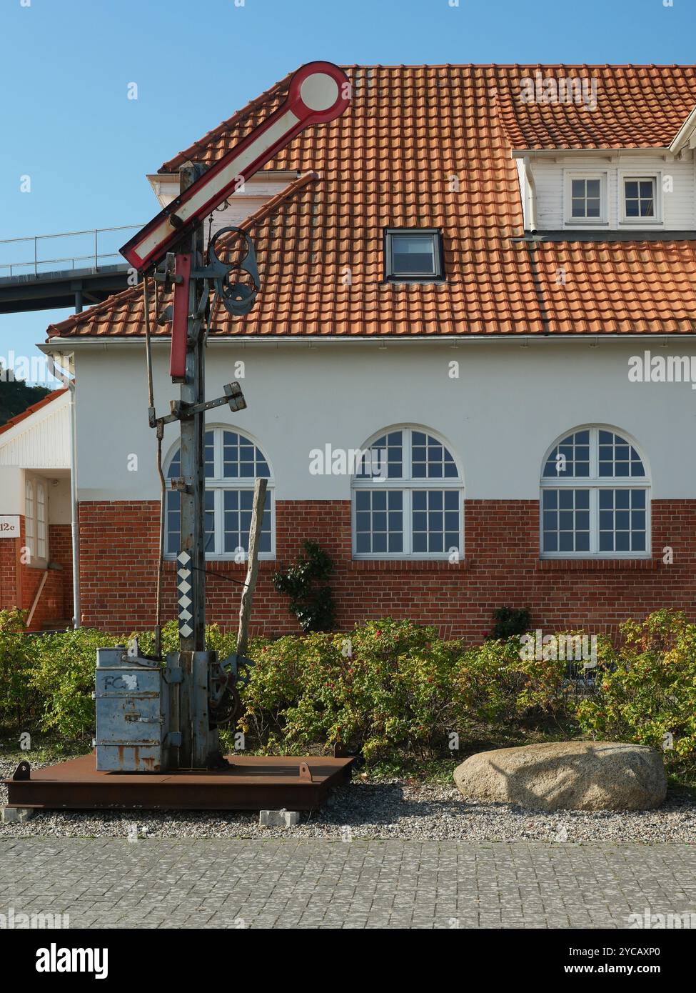 Il vecchio segnale a semaforo di fronte alla stazione portuale di Sassnitz ricorda un tempo in cui i treni erano ancora controllati a mano. Un monumento tecnico. Foto Stock