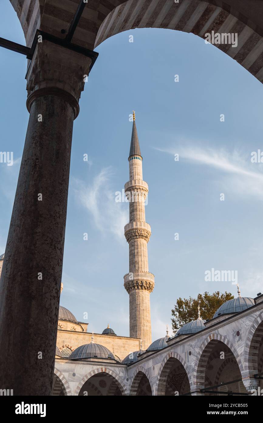 Una vista suggestiva che cattura l'eleganza del minareto della Moschea Blu incorniciato da archi, che mostra l'iconica architettura islamica di Istanbul. Foto Stock