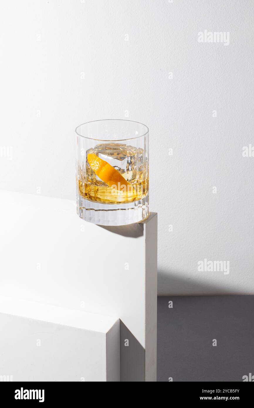 Foto minimalista di un bicchiere con rivestimento a buccia d'arancia su sfondo bianco geometrico Foto Stock