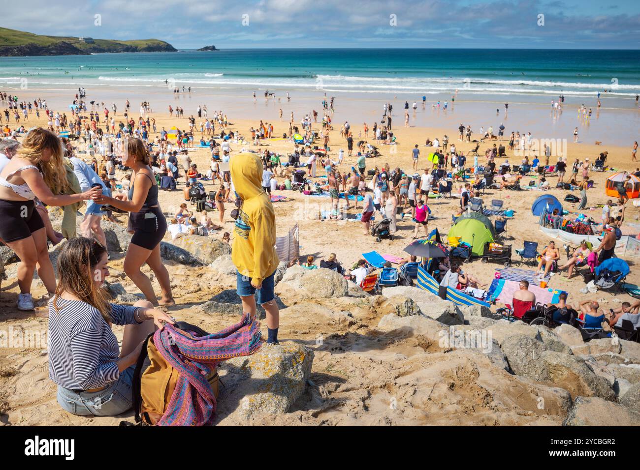 Turisti che si godono il sole estivo sull'iconica spiaggia Fistral di Newquay, in Cornovaglia, nel Regno Unito. Foto Stock