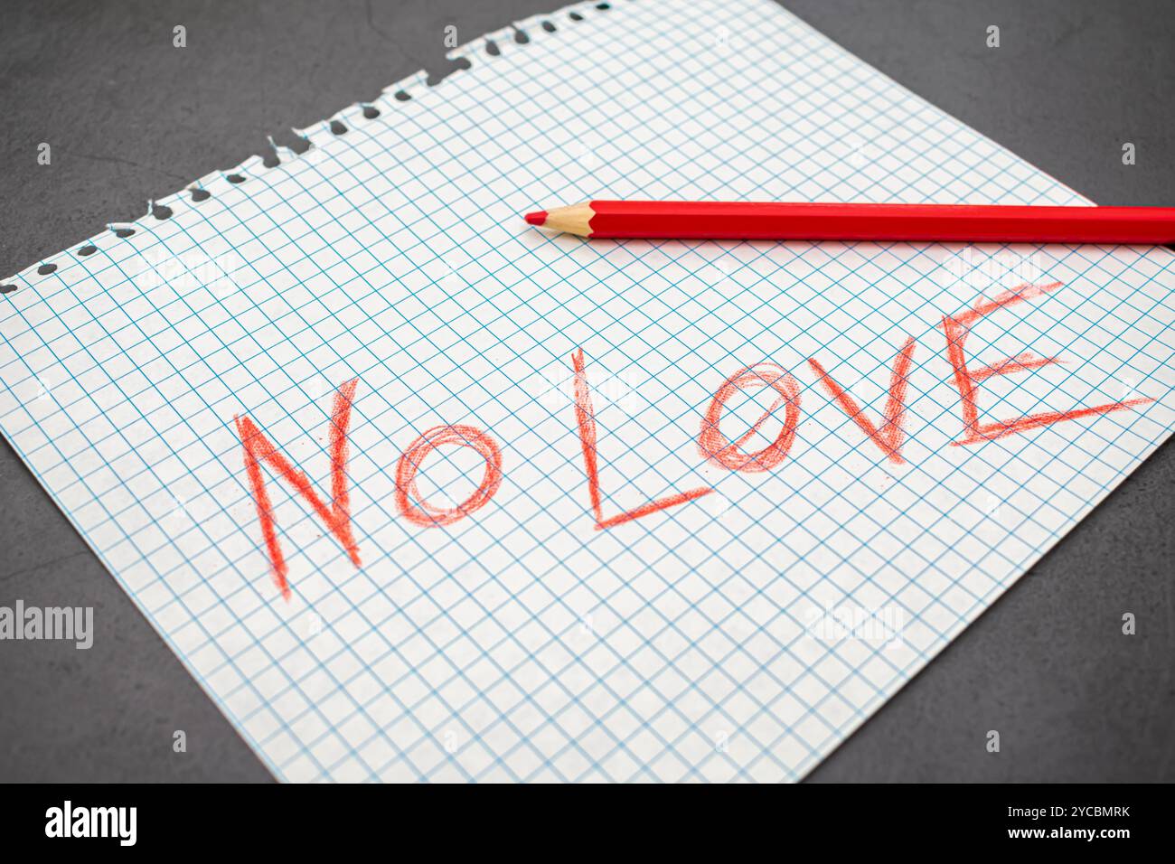 Frase triste senza amore scritta a matita rossa su un foglio di quaderno Foto Stock