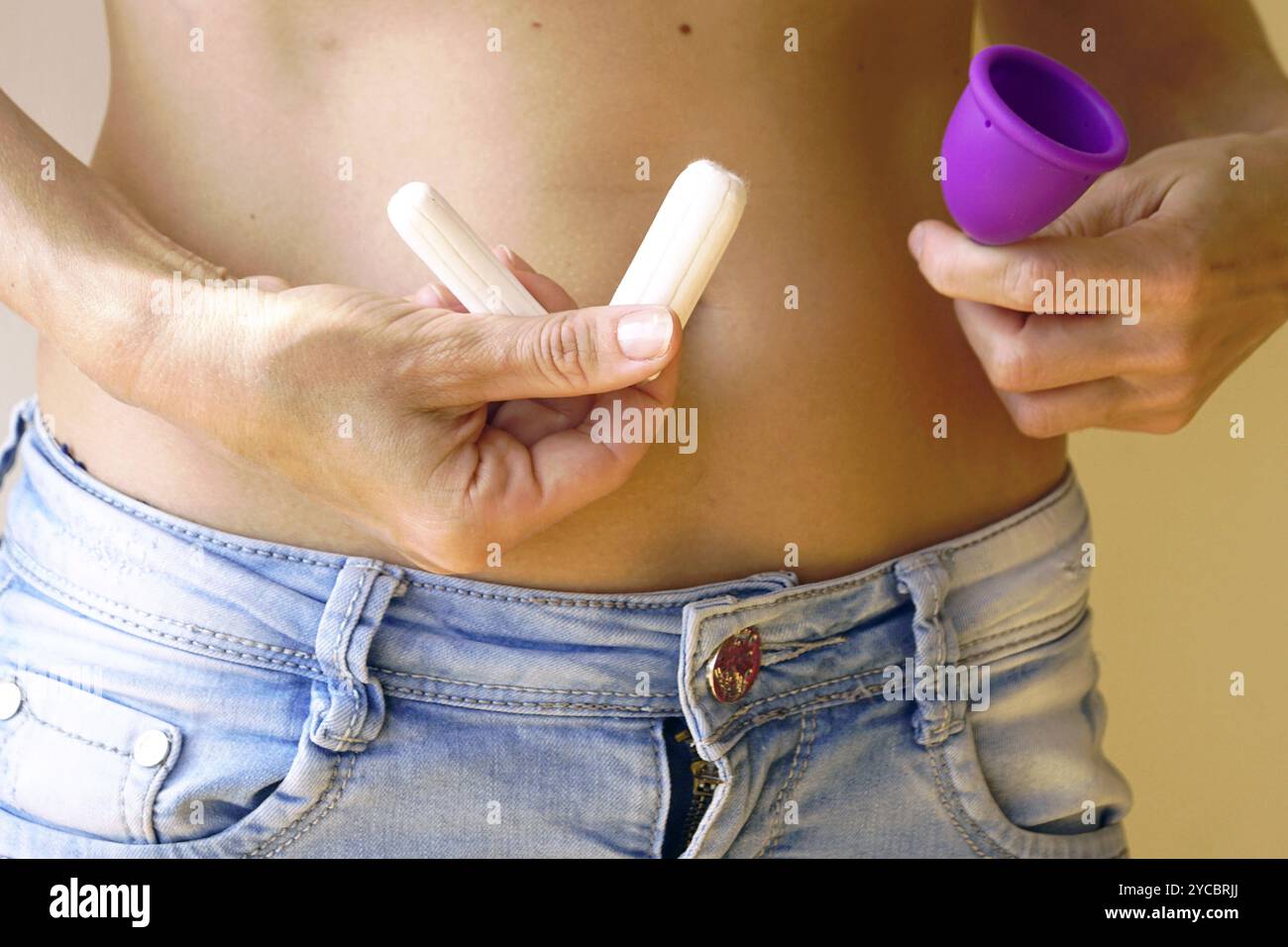 Una donna sceglie prodotti per l'igiene: Foto ravvicinata di tamponi di vari gradi di assorbenza e una tazza anatomicamente riutilizzabile nelle mani femminili. Foto Stock