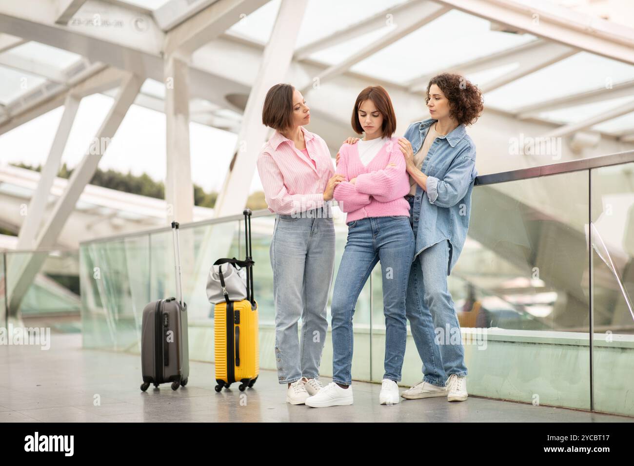 Tre amici che si godono momenti di viaggio in un moderno terminal aeroportuale Foto Stock