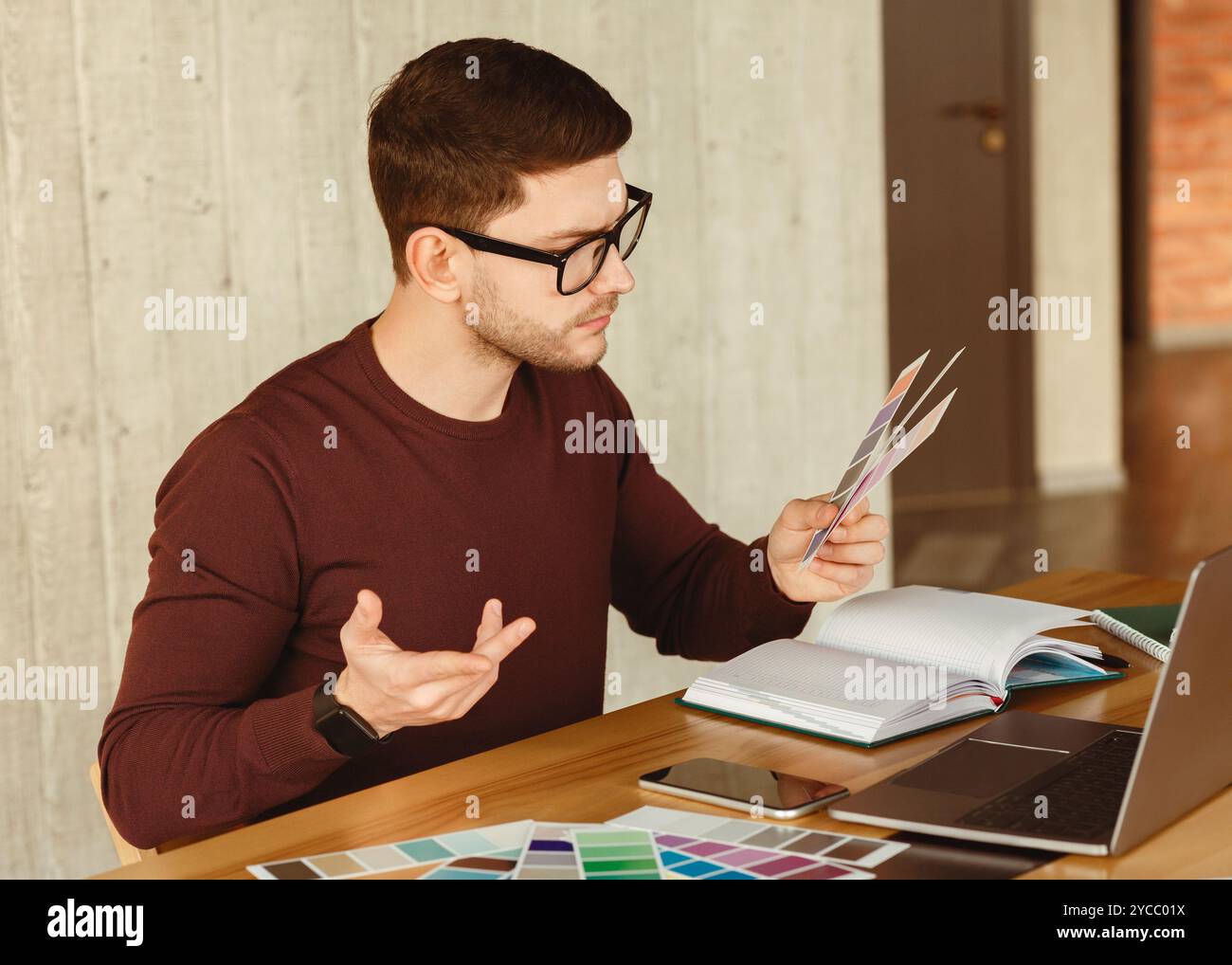 Freelance Designer Che Lavora Con I Campioni Di Colore Seduti In Ufficio Foto Stock
