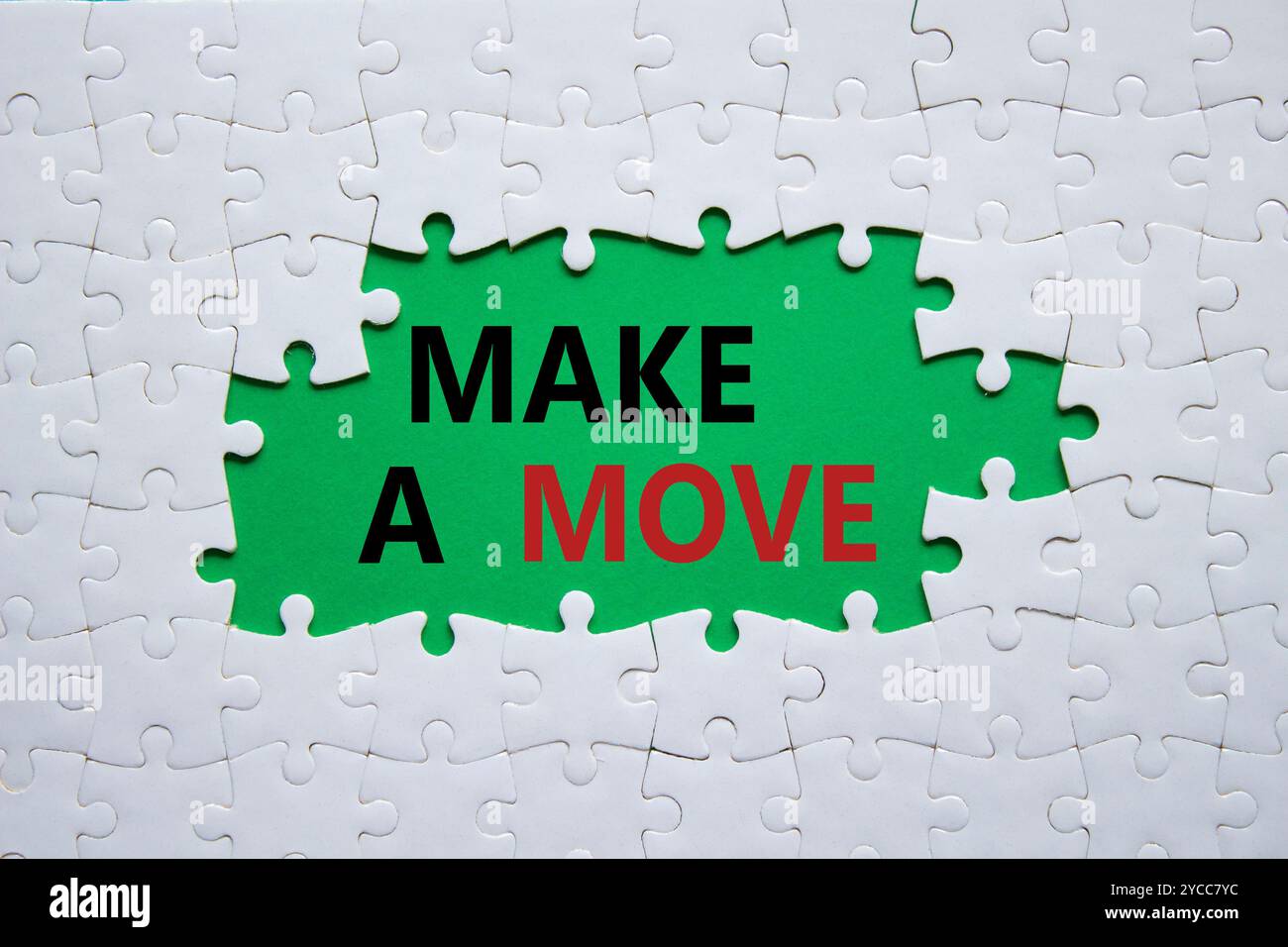 Simbolo di spostamento. Parola concettuale fai una mossa sul puzzle bianco. Bellissimo sfondo verde. Business and Make a Move. Copia spazio Foto Stock