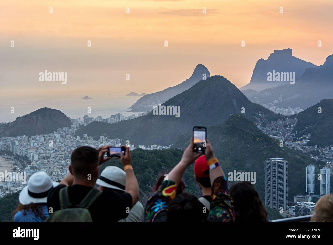 Persone che catturano il tramonto sul Pan di zucchero a Rio de Janeiro in Brasile Foto Stock