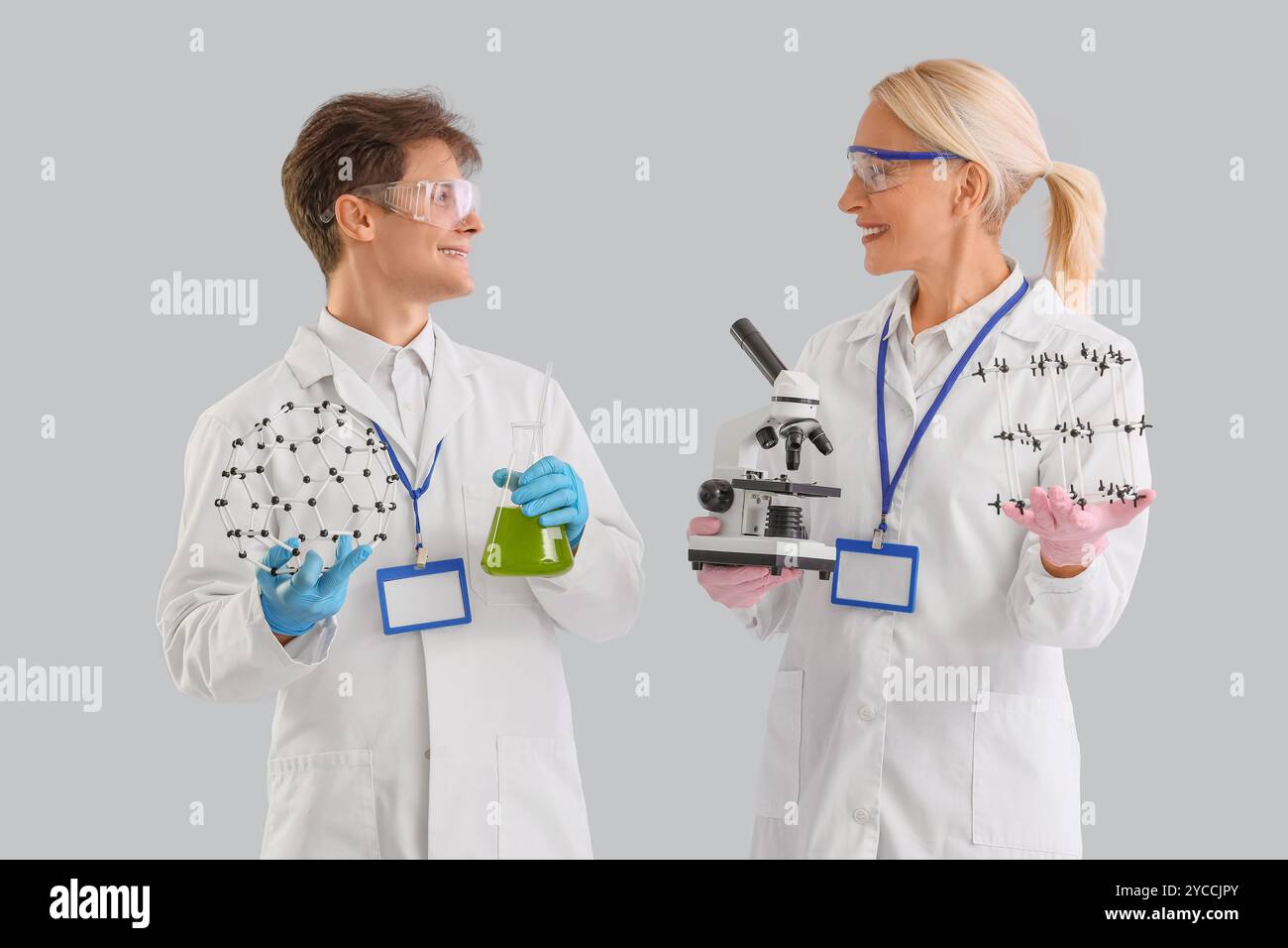 Chimici con microscopio e modelli molecolari su sfondo chiaro Foto Stock